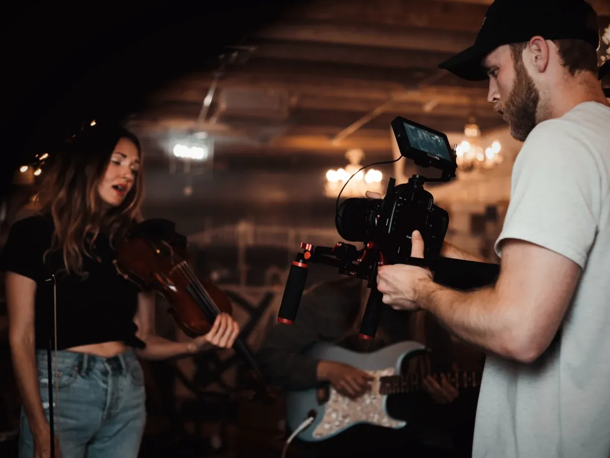 A violinist and a guitarist being filmed for a music video