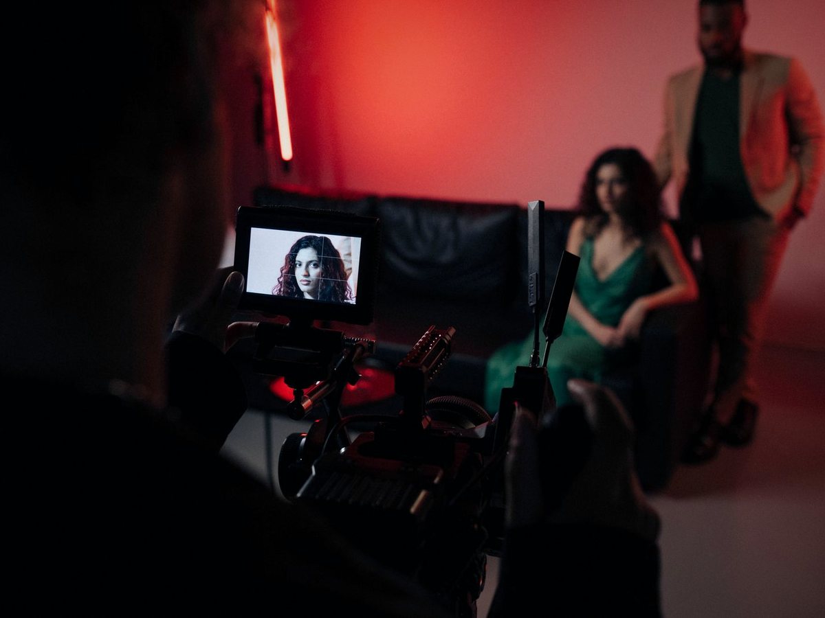 A campaign shoot under red light, the artist on the camera monitor